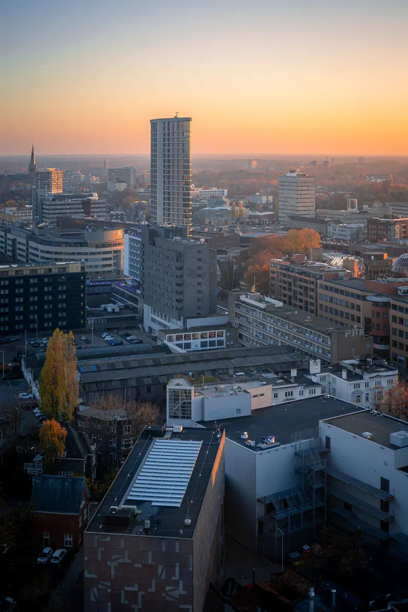 Aerial view over Eindhoven city rooftops and the Vestedatoren at sunset