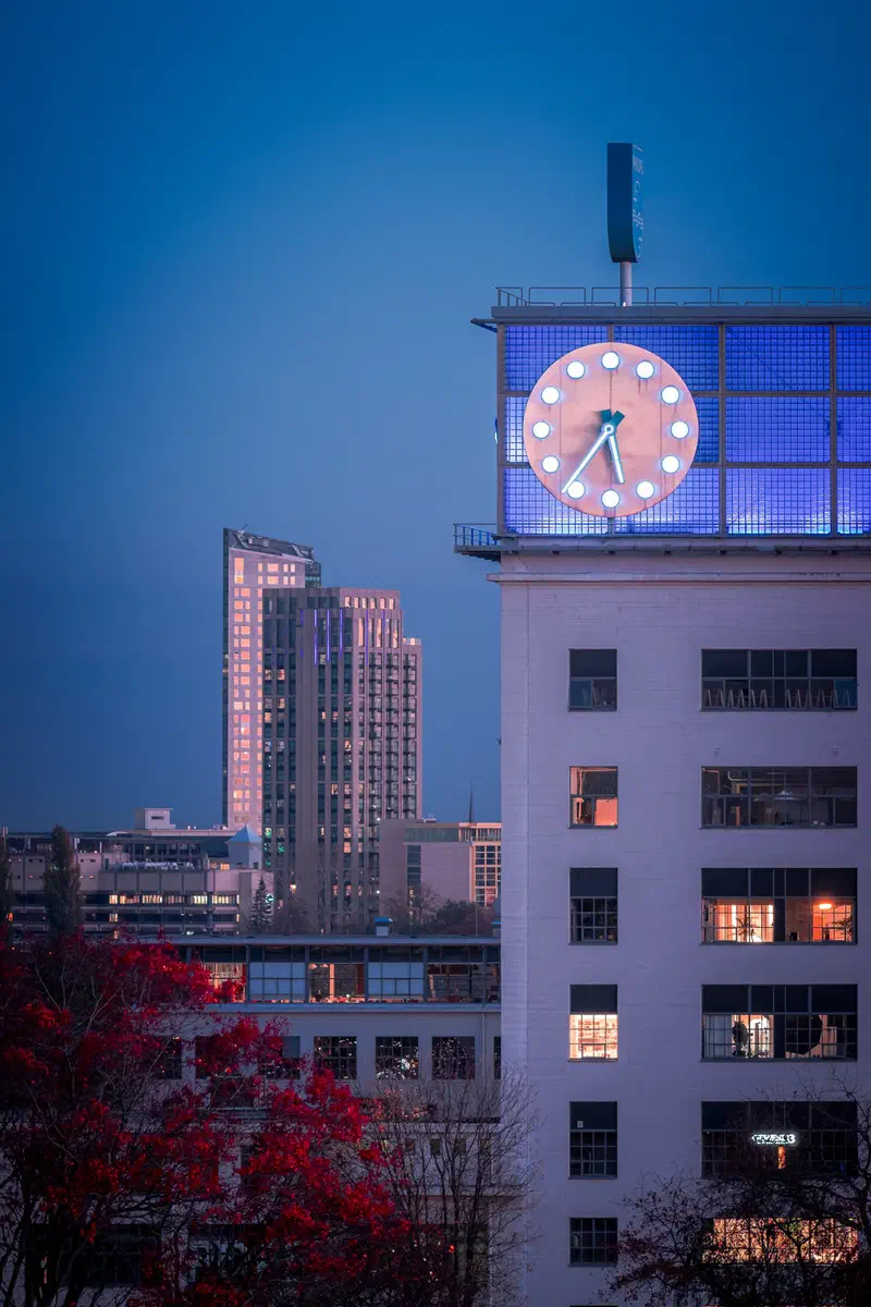 Illuminated clock tower (Klokgebouw) and high-rise at blue hour