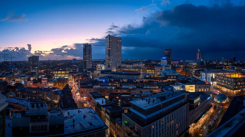 Skyline van Eindhoven in de schemering met naderende donkere onweerswolken