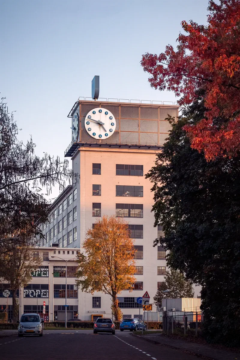 Klokgebouw clock tower beside red and orange autumn leaves, Strijp-S